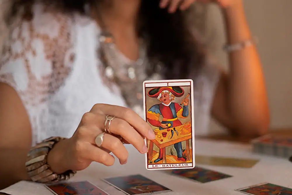 Mão apresentando uma carta de tarô